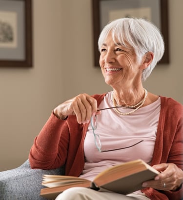 Mujer mayor disfrutando de la lectura, una excelente forma de estimulación cognitiva para fortalecer