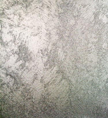 A cool silver paint sample showing off its shimmering grainy texture.