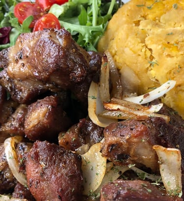 A plate of puerto rican food carne frita con mofongo