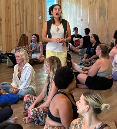 a woman in a white shirt is standing in a circle with other people