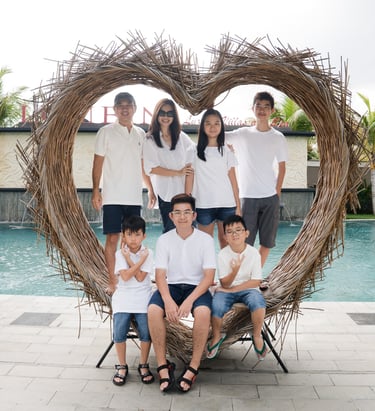 Family portrait inside heart frame during extended family photography at Lumbini Villas Jimbaran Bali by the pool