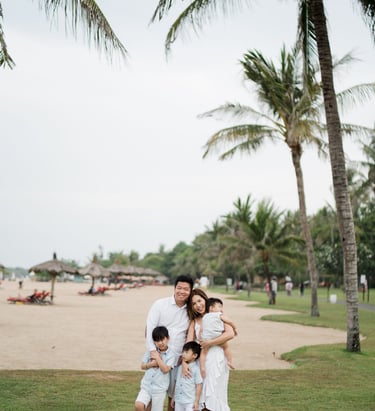 Family photography session at The Laguna Bali resort with tropical beach background