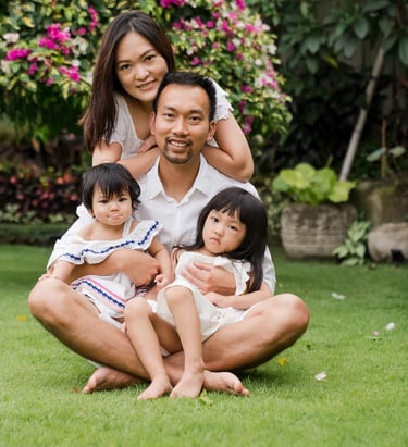 Natural family portrait in the garden of a private villa in Seminyak Bali with calm tropical surroundings and genuine