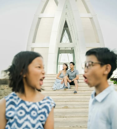 Family standing in front of the iconic chapel during a luxury family photography session at The Ritz-Carlton Bali.