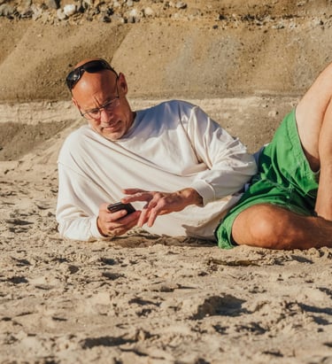 Uomo maturo in viaggio che controlla lo smartphone per restare connesso e gestire situazioni a dista