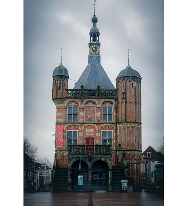 Photograph of a traditional Dutch building in front of a looming grey sky.