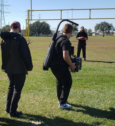 Video content production onsite on a football field with a player.