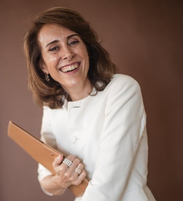 a female life coach in a white jacket holding a brown clutch