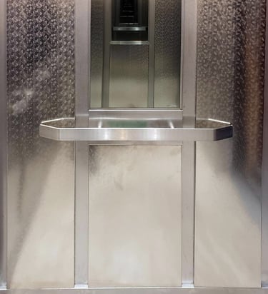 elegent elevator interior with embossed steel, flat handrails and a mirror