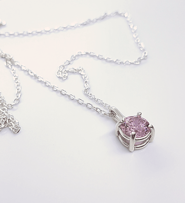 a necklace with a pink crystal pendant on a chain
