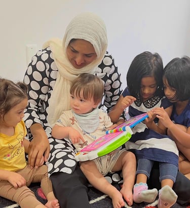 Caregiver and children reading an electronic book at daycare