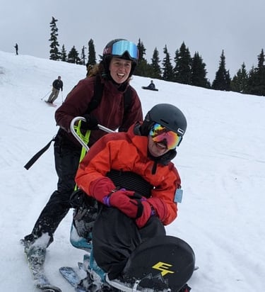 Sean and ski partner Jacqueline skiing towards the camera smiling