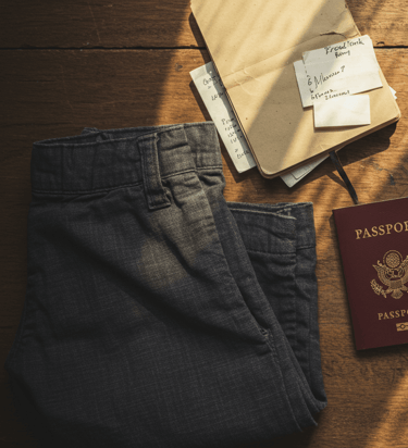 image of comfortable and stylish travel pants, camara, passport, map, and sunglasses
