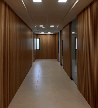 Pasillo con acabado de madera en muros y plafón con luminarias LED | KARÄNA