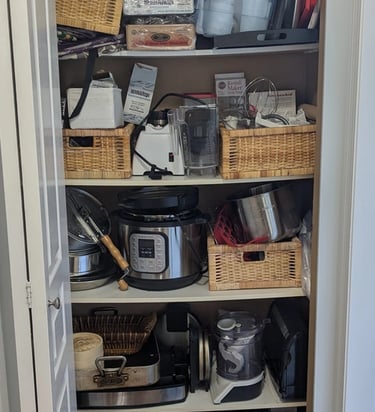 Kitchenware closet with bowed melamine shelving and disorganized clutter