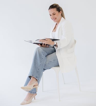 Bilde av grafisk designer Rasa June som sitter på en stol