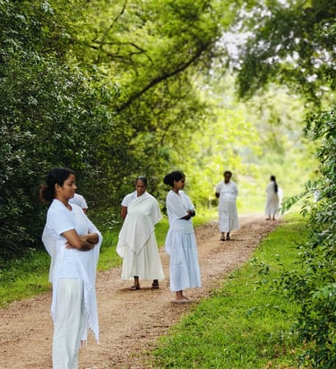 a group of people in white dresses walking down a path
