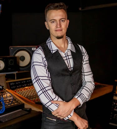 Guitarist and singer Lucas Vianna wearing a white shirt with black stripes and a black vest.