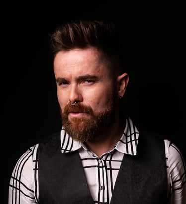 Singer Leo Couto wearing a white shirt with black stripes and a black vest.