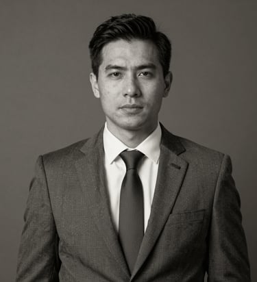 Professional corporate headshot of a man in a formal business suit and tie.