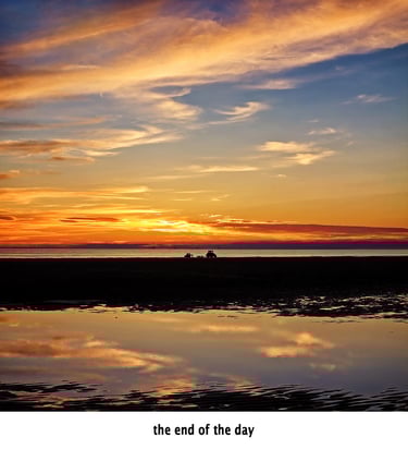 a sunset with a lone tractor in the foreground