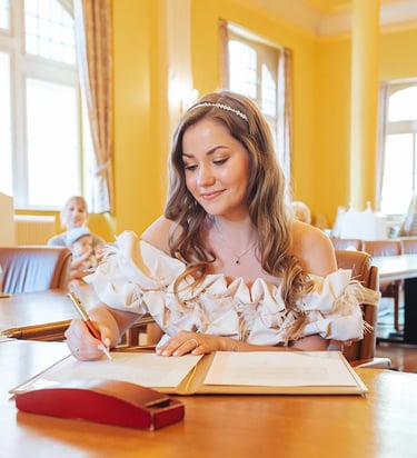 Jeune mariée qui signe les documents de son mariage civil en mairie