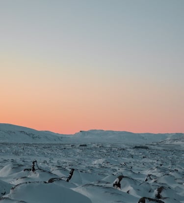a snow covered mountain with a pink sky
