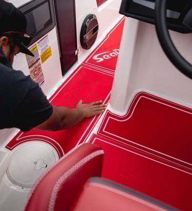 Vital Marine installer fitting custom red SeaDek flooring during professional boat deck installation
