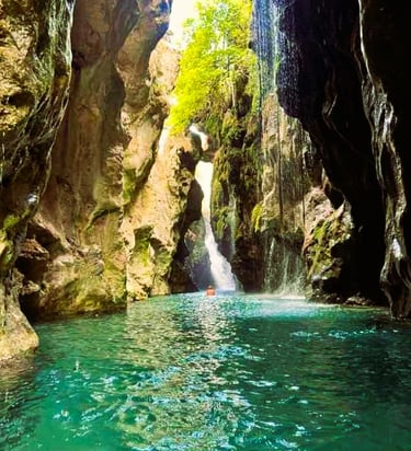 Steep cliffs of Kourtaliotiko Gorge with a river and small waterfalls