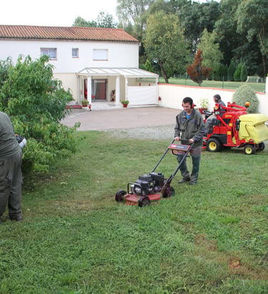 ouvriers espaces verts tondant la pelouse et débrousaillant