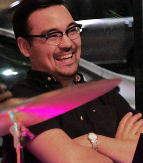 Smiling keyboardist Shawn Schlogel on a musical set