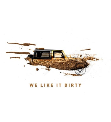 Jeep 'We Like It Dirty' creative ad showing a mud-splattered Jeep, emphasizing rugged performance.