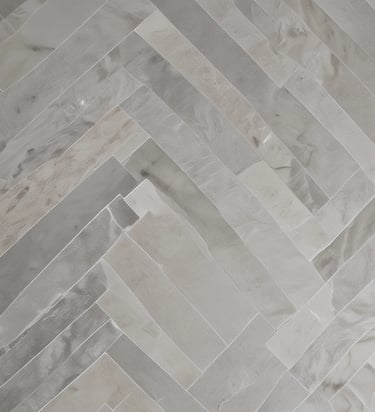 A tiled surface composed of small, square tiles in a grid pattern. There is a slight color variation indicating dampness on part of the surface. The corner of a shoe is visible at the bottom right corner.