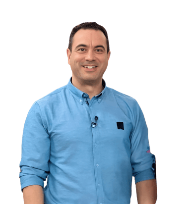 Smiling man in a blue button-down shirt posing against a black background for a professional headshot.