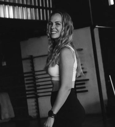 black and white picture. personal trainer posing for picture in gym setting