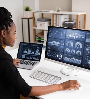 a Data Scientist black woman sitting at a desk with a laptop looking at data visulization i