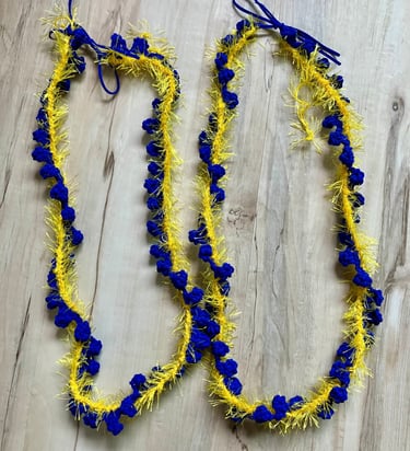 2 royal blue and yellow leis lying side by side