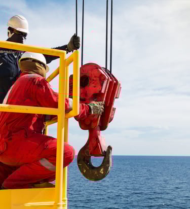 offshore API crane hook being inspected by 2 technicians