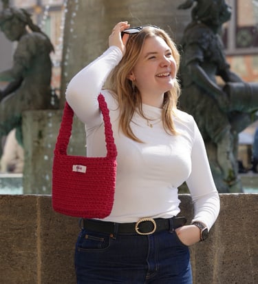 Leni von Frisie mit der handgehäkelten roten Marienplatz Magic Tasche – handgemacht in München, foto