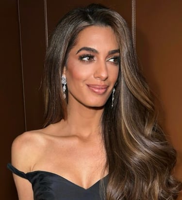 a woman in a black dress with long hair and earrings