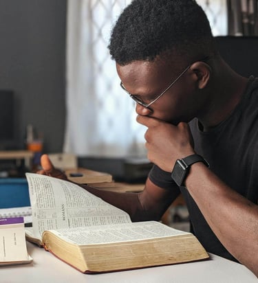 a man sitting at a desk with a bible