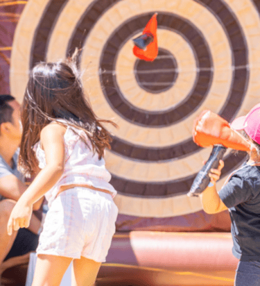 a young girl is playing with a blow up in a bouncer carnival event planner carnival games