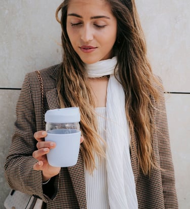 daugkartinis kavos puodelis moters rankose