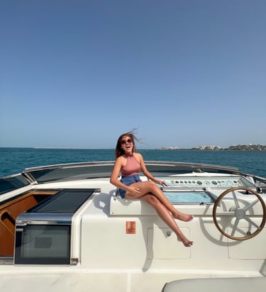 a woman sitting on a boat yacht in the ocean in dubai