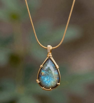 Close-up of a delicate gold necklace with a small diamond pendant resting on a soft white fabric.