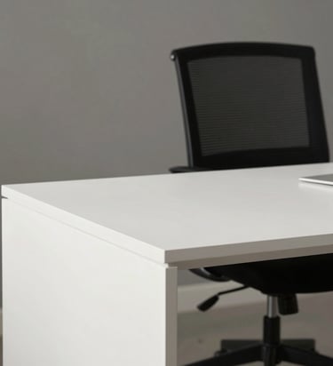 A professional photography shot of a clean, minimalist workspace in a North American / US home office, featuring a white desk and a black designer chair.
