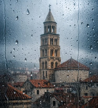 Saint Domnius Bell Tower in Split, Croatia, viewed through a rainy window with water droplets.