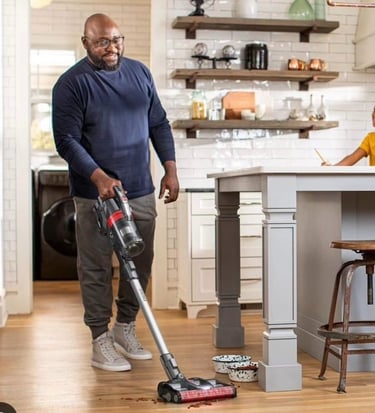 Man with a vacuum cleaning up pet food in a photoshoot