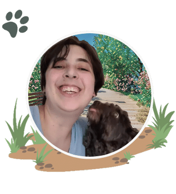 Julia Goldhirsh headshot in Boston Massachusetts with a black fluffy dog licking their face