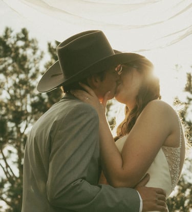 bride and groom portrait, kissing, sunlight
